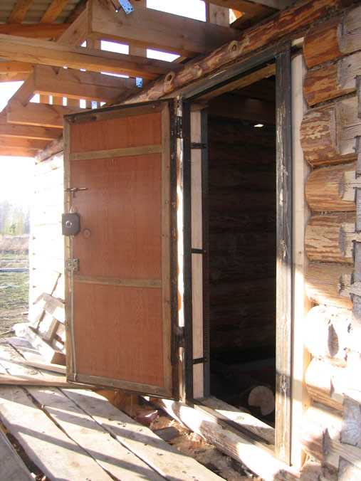 Железная дверь в деревянном доме. Двери в деревянном доме. Металлическая дверь в деревянный проем. Установленная входная дверь в дом. Монтаж входной двери в деревянном доме.